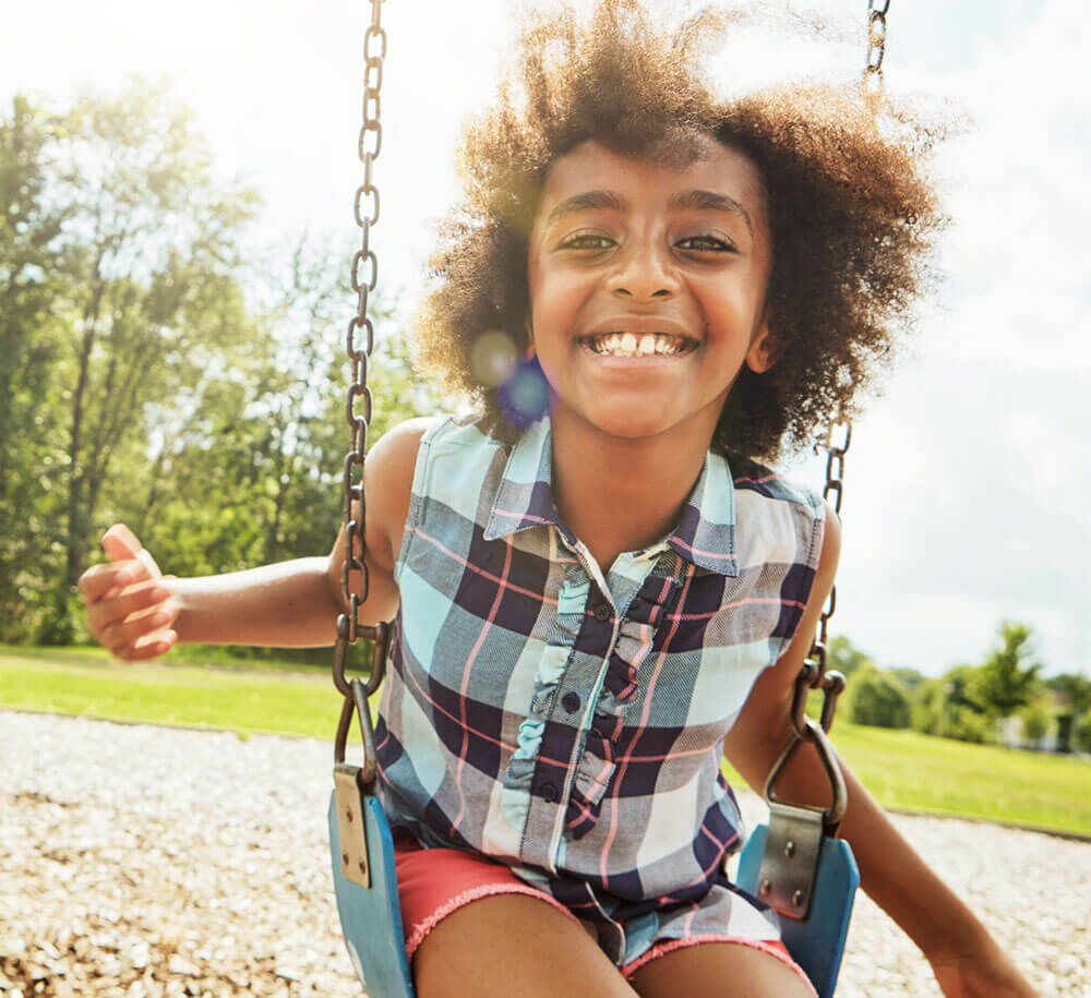 Girl Swinging on a swing and smiling